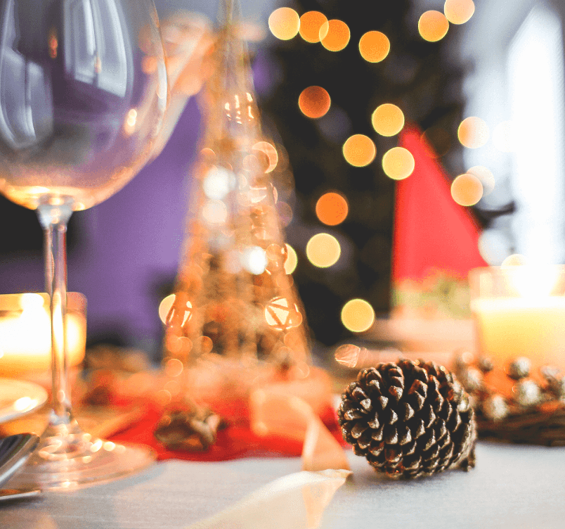 Christmas table close up of pine cone and empty wine glass